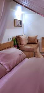een woonkamer met een bed en een bank bij Orchid Gardens; Studio Apartment, minimalist in Kampala