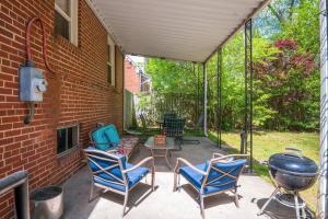 un patio con sillas azules y una parrilla en Private House + Yard Central Location to all RVA, en Richmond