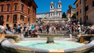 Ein Brunnen mitten in einer Stadt mit einer Menschenmenge in der Unterkunft Eden LUXURY ROMA in Rom