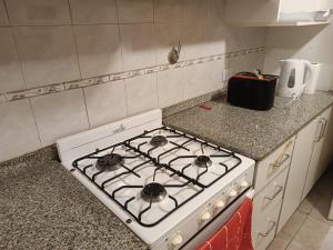 La cocina está equipada con fogones blancos. en Las Heras 361 en San Miguel de Tucumán