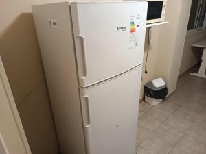 einen weißen Kühlschrank in einer Küche neben einer Mikrowelle in der Unterkunft Las Heras 361 in San Miguel de Tucumán