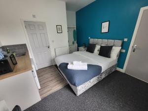 a bedroom with a bed with a blue wall at Stay Sleep Rest - Forest Road in Nottingham