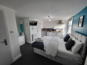 a bedroom with a large bed and a kitchen at Stay Sleep Rest - Forest Road in Nottingham