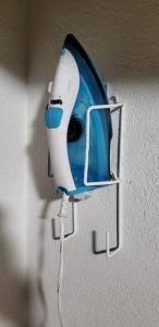 Un secador de pelo azul y blanco colgado en una pared. en Loft Centrico 3 camas matri, minisplit, estacionamiento, refrigerador,microhondas ( 3), en Ciudad Valles