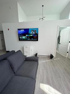 a living room with a couch and a flat screen tv at White Baltimore Condo in Baltimore