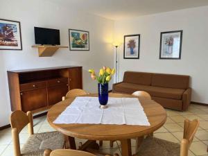 ein Wohnzimmer mit einem Tisch und einer Blumenvase darauf in der Unterkunft Apartments in Lignano 21662 in Lignano Sabbiadoro