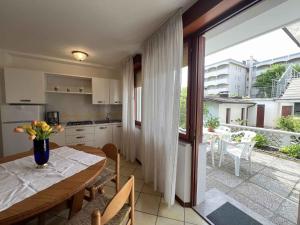 eine Küche und ein Esszimmer mit einem Tisch und einem Balkon in der Unterkunft Apartments in Lignano 21662 in Lignano Sabbiadoro