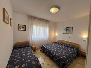 1 Schlafzimmer mit 2 Betten und einem Fenster in der Unterkunft Apartments in Lignano 21662 in Lignano Sabbiadoro