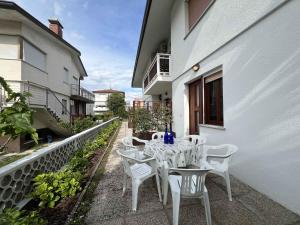 einen weißen Tisch und Stühle auf dem Balkon eines Gebäudes in der Unterkunft Apartments in Lignano 21662 in Lignano Sabbiadoro