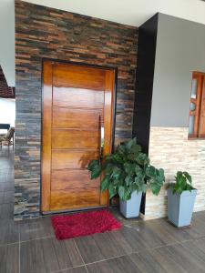 una puerta de madera con dos macetas delante de ella en Recanto Orlumahe, en Pardinho