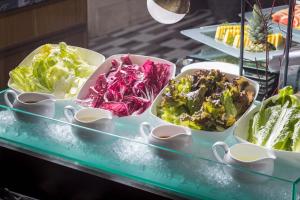 un buffet lleno de diferentes tipos de ensaladas en bandejas en Kichijoji Excel Hotel Tokyu en Musashino