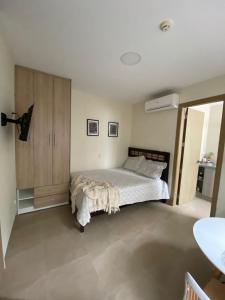 1 dormitorio con 1 cama y armario de madera en Minisuite entrada lateral, seguridad y privacidad en Samborondón
