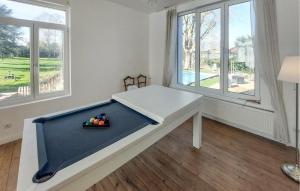 ein weißes Zimmer mit einem Tisch und Fenstern in der Unterkunft Lovely Home In Feignies With Wifi in Feignies