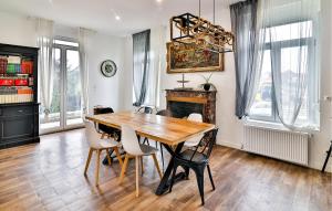 ein Esszimmer mit einem Holztisch und Stühlen in der Unterkunft Lovely Home In Feignies With Wifi in Feignies