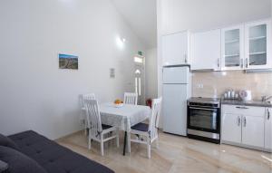 eine Küche mit einem Tisch und Stühlen sowie einem Kühlschrank in der Unterkunft 1 Bedroom Beautiful Apartment In Komarna in Komarna