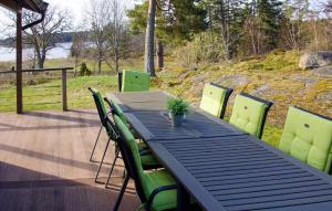 a wooden table with green chairs on a deck at Beautiful Home In Sankt Anna With Kitchen in Sankt Anna