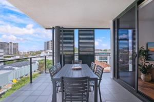 a dining table on a balcony with a view of the city at Regatta Hideaway - A Breezy Balcony Residence in Brisbane