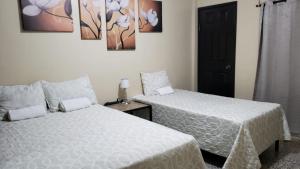 1 dormitorio con 2 camas y puerta negra en Casa Altamira, en San Pedro Sula