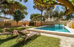 ein Hinterhof mit einem Pool mit Stühlen und einem Tisch in der Unterkunft Nice Home In Chiclana De La Fronter in Chiclana de la Frontera