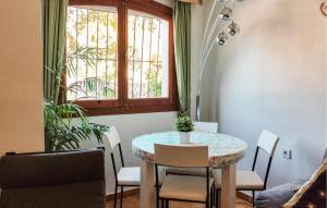 オリフエラ・コスタにあるCozy Home In Orihuela Costa With Kitchenのダイニングルーム(テーブル、椅子、窓付)