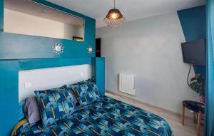 a bedroom with a bed and a blue wall at Awesome Home In Saint-Michel-Chef-Chef in Saint-Michel-Chef-Chef
