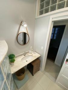 a bathroom with a sink and a mirror at Casa da Varanda Próximo Centro in Petrópolis +28 photos