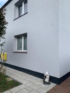 a fire hydrant sitting in front of a white building at 75 m2 Apartment - Private House in Rumia