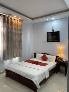a bedroom with a large bed with white sheets at Tuan Long Hotel in Ho Chi Minh City +93 photos