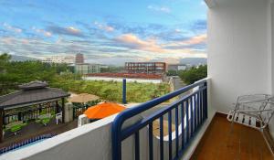 慶州的住宿－貝尼凱瑞士羅森酒店，阳台配有橙色遮阳伞,享有城市美景