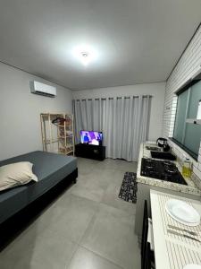 een woonkamer met een bed en een tv. bij 2- Studio Prox Uel e catuai c/ar in Londrina