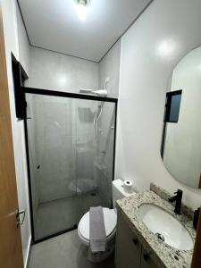 een badkamer met een douche, een toilet en een wastafel bij 2- Studio Prox Uel e catuai c/ar in Londrina