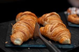 a group of croissants on a black plate with a spatula at SLS Buenos Aires Puerto Madero in Buenos Aires