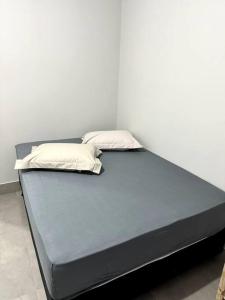 een bed met twee kussens erop bij 2- Studio Prox Uel e catuai c/ar in Londrina