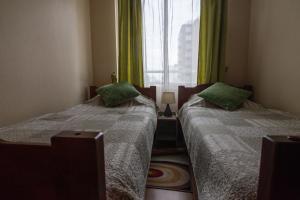 2 camas en una habitación pequeña con ventana en Departamento central, 2 Dormitorios 4 personas, en Viña del Mar