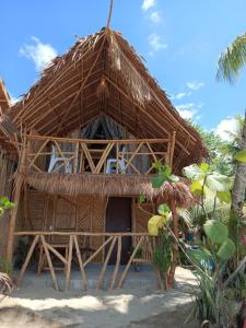 une cabane avec un toit de paille sur la plage dans l'établissement 8 Star Paradise, à Locaroc