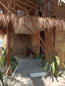 a straw hut with a table and a bench at 8 Star Paradise in Locaroc