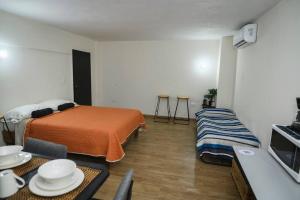 a bedroom with a bed and a table with plates on it at Departamento de 2 recamaras con 2 aires acondiconados, parking, wifi 70mb, refrigerador, micro,fregadero,licuadora,parrilla, cocina, D5 in Ciudad Valles