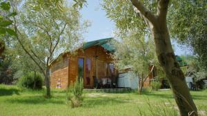 Cabaña de madera pequeña con porche en el césped en Agriturismo Tres Montes en Sorso