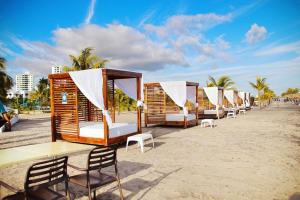 a row of wooden cabanas on the beach at Villa Oceánica in Playa Blanca