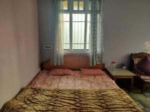 um quarto com uma cama grande e uma janela em Mountain Valley Homestay em Temi