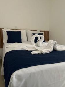 Una cama con un cisne hecho de toallas en Hotel Areião, en Goiânia