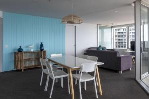 - un salon avec une table, des chaises et un canapé dans l'établissement Q1 Resort & Spa - Official, à Gold Coast