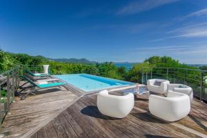 a deck with chairs and a swimming pool on a house at Villa El Désert in Sainte-Luce