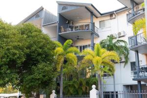 um edifício com palmeiras em frente em Tropical Bliss in Woolner em Stuart Park