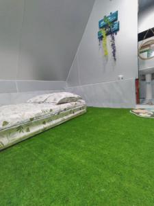 1 dormitorio con cama y alfombra verde en Homestay Hang Câu, en An Vĩnh Phướng