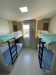 une chambre avec trois lits superposés et une fenêtre dans l'établissement M6 - Apto, Cancun, Novo e confortável, à Foz do Iguaçu