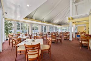 una sala da pranzo con tavoli, sedie e finestre di Ocean Creek 2208 a Myrtle Beach
