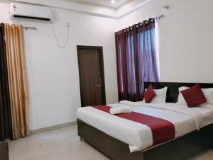 um quarto com uma cama grande e almofadas vermelhas em The Champ Palace em Lucknow
