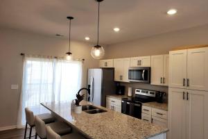 a kitchen with white cabinets and a counter top at The Prairie at Coventry Rows in Omaha