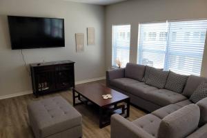 uma sala de estar com um sofá e uma televisão de ecrã plano em The Prairie at Coventry Rows em Omaha